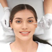 Uśmiechnięta kobieta w trakcie zabiegu mezoterapii igłowej w gabinecie Prestige Laser we Wrocławiu.