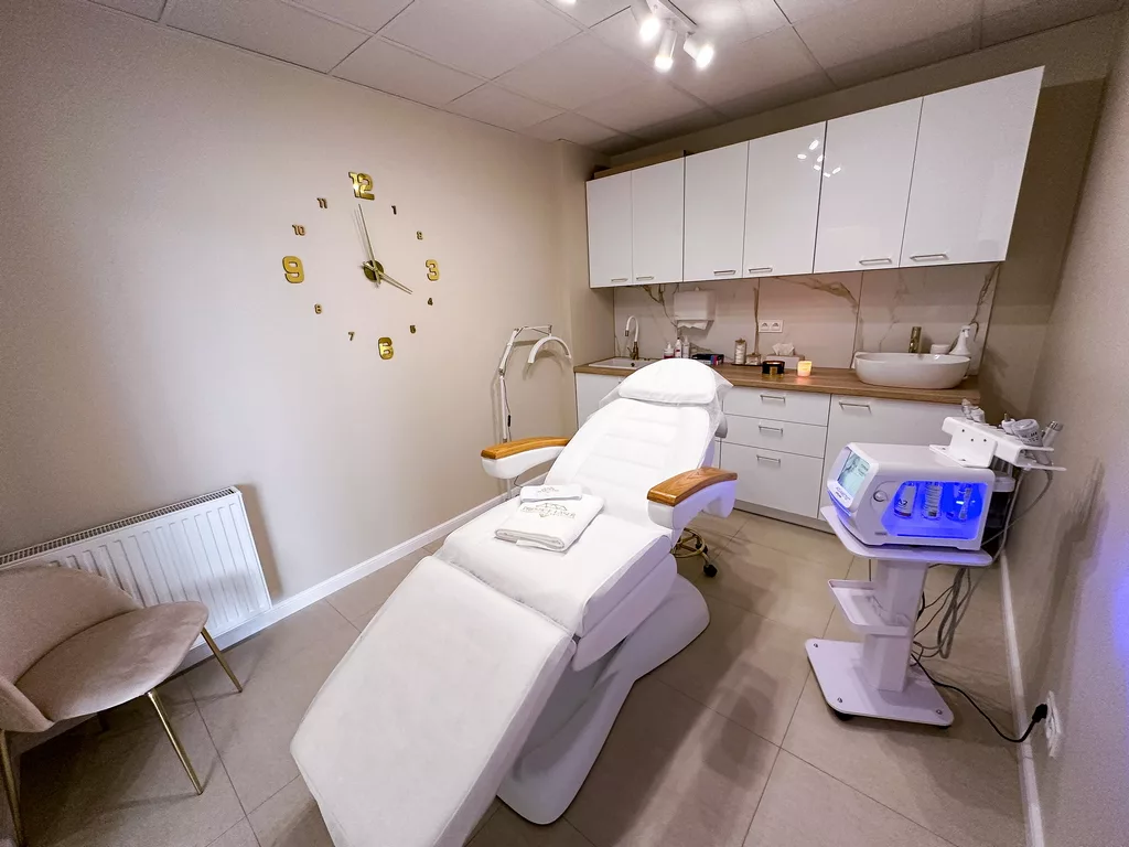 Gabinet zabiegowy w salonie Prestige Laser Kosmetologia Estetyczna we Wrocławiu – eleganckie wnętrze z białym fotelem, urządzeniem Aquametiq Hydra Prime i złotymi detalami.